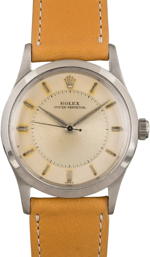 A vintage Rolex Oyster Perpetual 6532 watch featuring a tan leather strap and elegant silver casing.