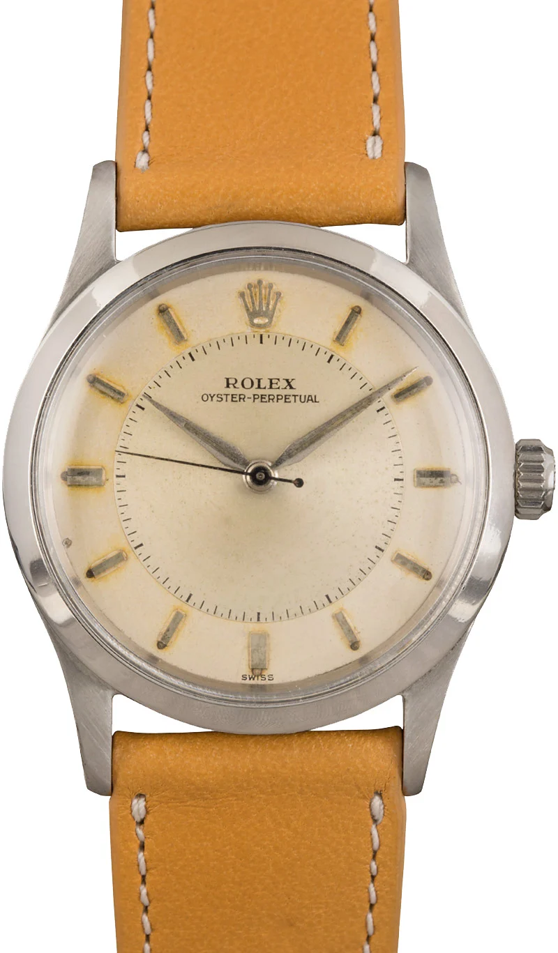 A vintage Rolex Oyster Perpetual 6532 watch featuring a tan leather strap and elegant silver casing.