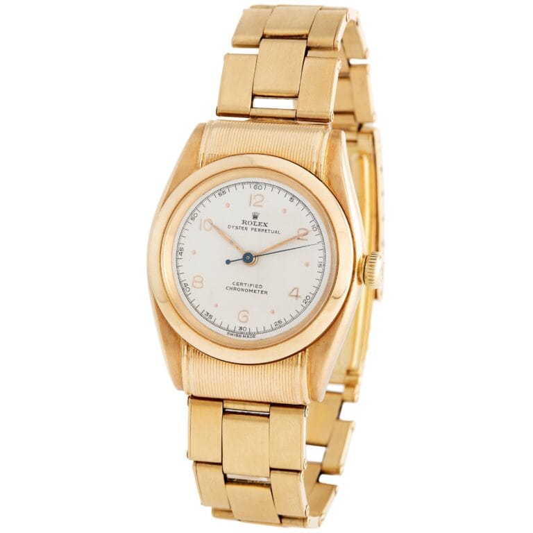 Gold Rolex Oyster Perpetual 6065 wristwatch with a white dial and gold bracelet, shown at an angle.