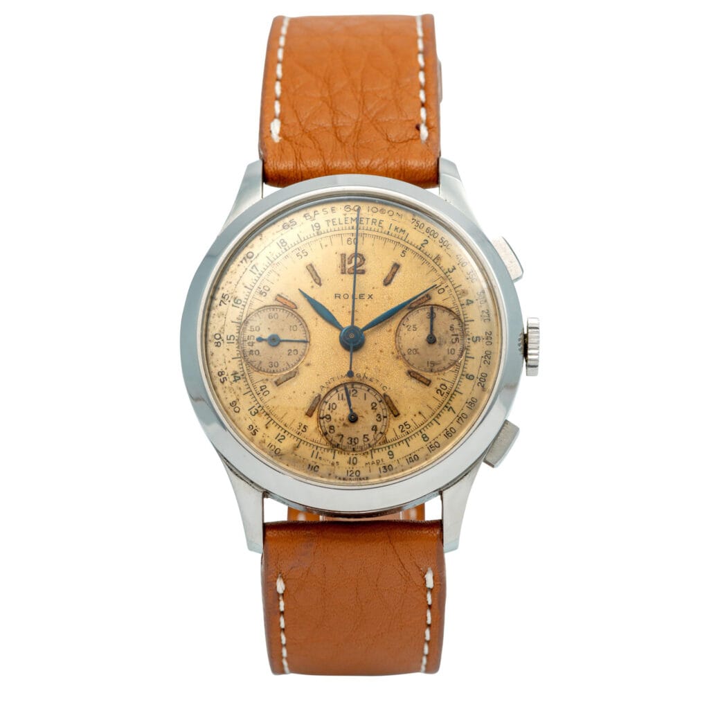 Vintage Rolex Chronograph 3335 watch with a tan leather strap and aged yellow dial, featuring multiple subdials.
