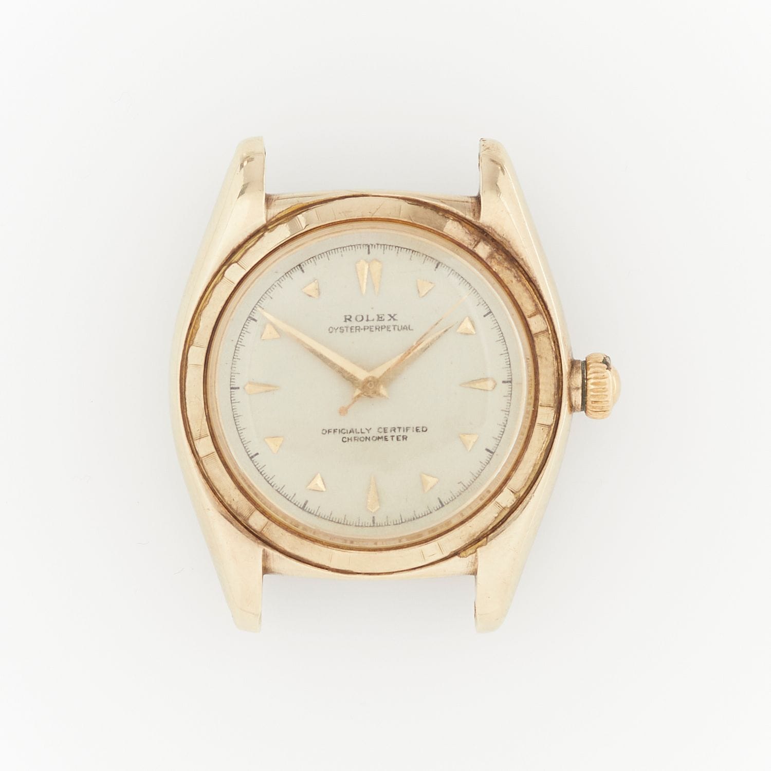 A vintage gold Rolex Oyster Perpetual wristwatch with a white dial and gold hour markers, photographed from above.