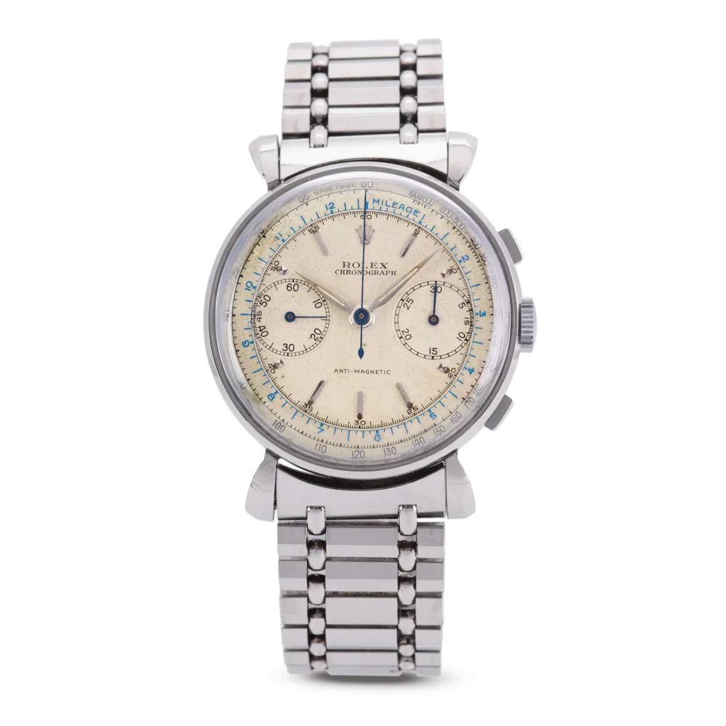 A vintage Rolex Chronograph wristwatch with a silver metal band and a cream-colored dial, this classic piece is reminiscent of the sought-after Rolex 4099 models.