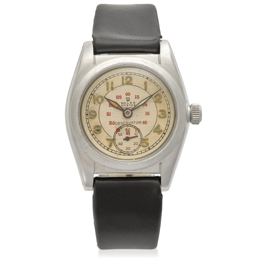 A vintage Rolex Oyster 2765 wristwatch with a cream dial, black leather strap, and striking red and gold numbers.