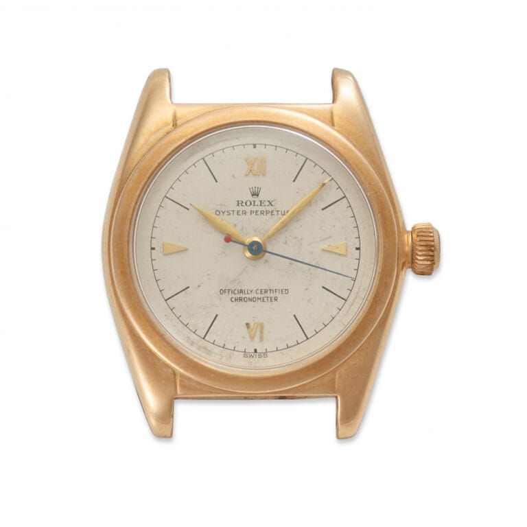 Vintage gold Rolex Oyster Perpetual 5050 watch featuring a white dial and gold hour markers, missing its band.