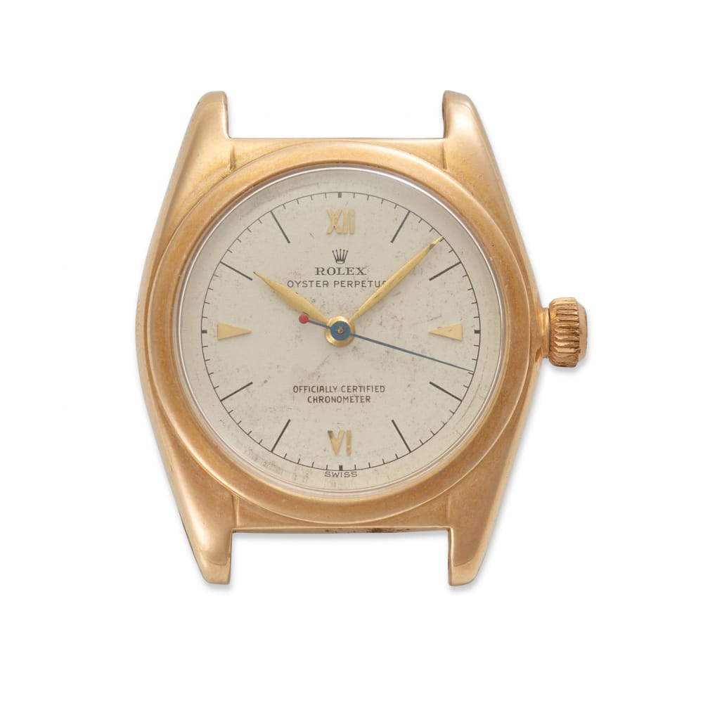 Vintage gold Rolex Oyster Perpetual 5050 watch featuring a white dial and gold hour markers, missing its band.