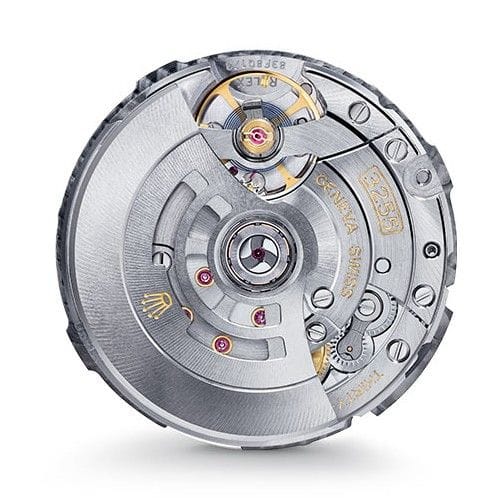 Close-up of a mechanical watch movement with visible gears, screws, and intricate metal details.