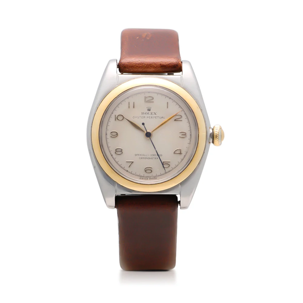 A vintage Rolex Oyster Perpetual wristwatch with a brown leather strap and a gold and silver round case, model 4919.