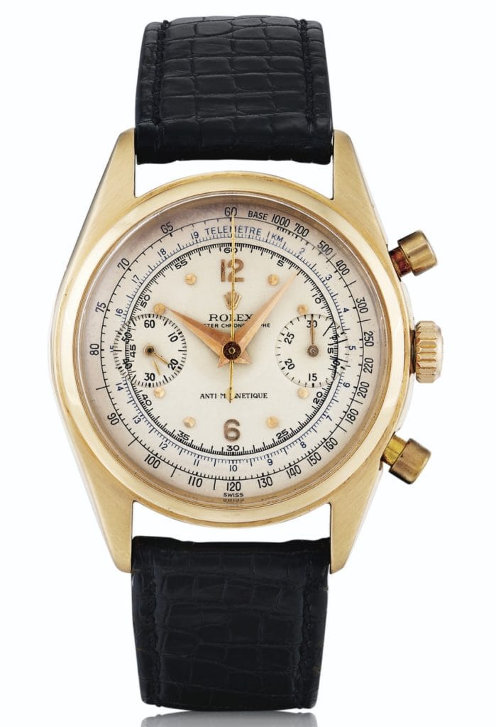 Gold vintage Rolex Chronograph 6032 watch with black leather strap and two subdials on a white face.