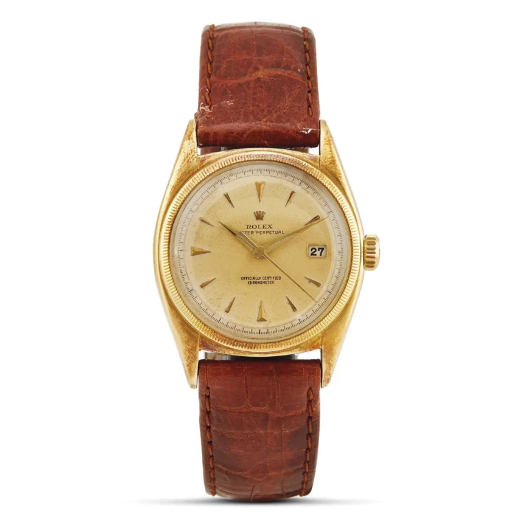 Gold Rolex Oyster Perpetual 6075 wristwatch with a brown leather strap and a date display on the right side of the dial.