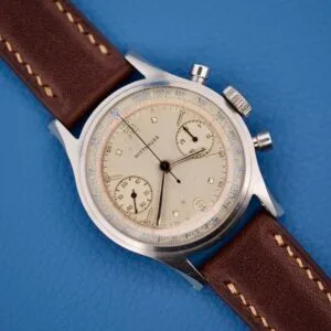 The Wittnauer Chronograph Venus 188 features the acclaimed Venus 188 movement and comes with a brown leather strap, showcased on a blue textured background.