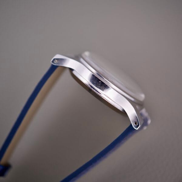 Side view of a Wittnauer 3256 Chronograph Venus 188 wristwatch case with blue straps, set against a plain light background.