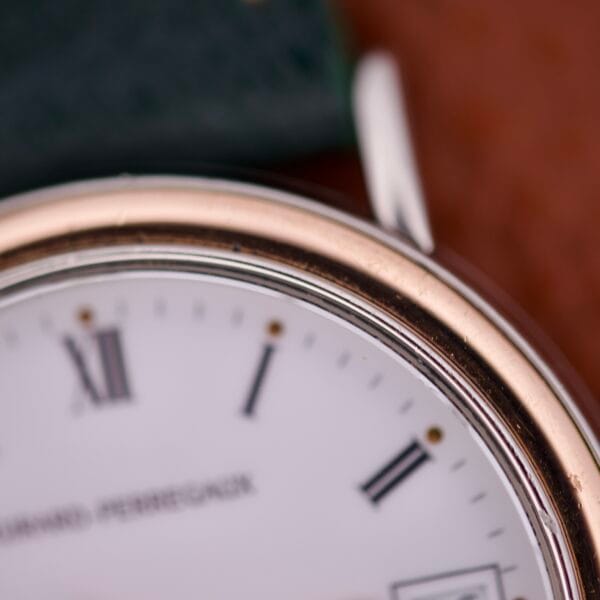 Close-up of the Girard Perregaux Automatic 4797 watch face, showcasing Roman numerals, a metal bezel, and its signature automatic movement.