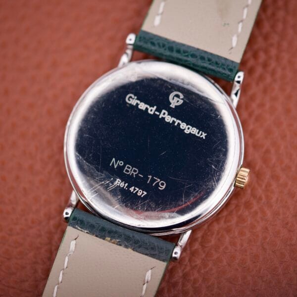 The back of the Girard Perregaux Automatic 4797 watch features engraved details and visible scratches.