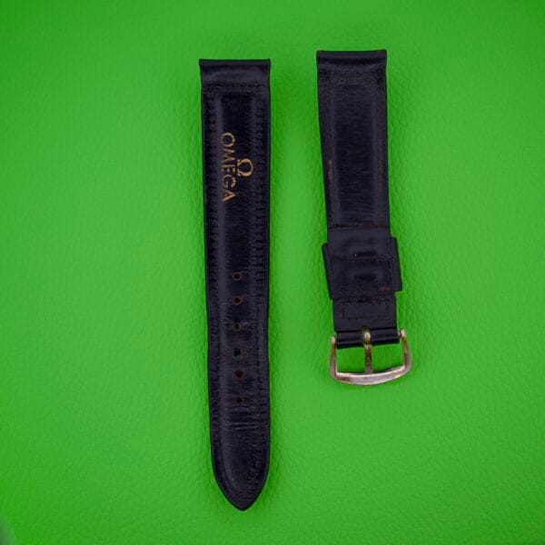Two black leather Omega Automatic Bumper 2635 Original Straps on a bright green textured background.