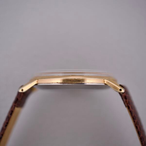 Side view of a Movado Jumbo Manual Wind Sub Seconds gold wristwatch with a brown leather strap, shown against a plain light background.