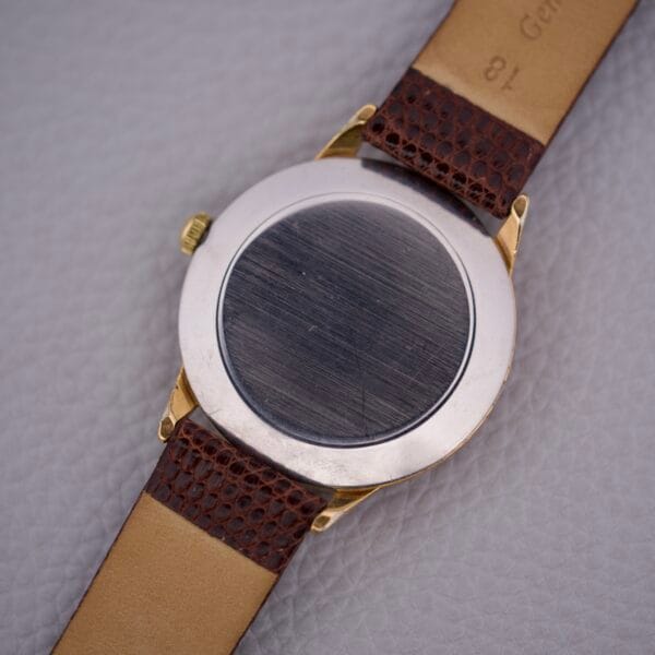 A close-up of the Movado Jumbo Manual Wind Sub Seconds wristwatch with a brown leather strap, highlighting its jumbo case on a textured surface.