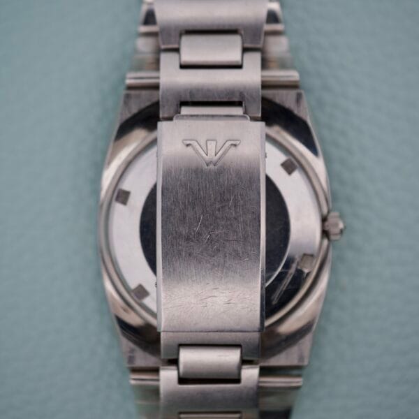 Close-up of a Wittnauer Diver Bakelite Bezel 1002-W100 watch in silver metal, highlighting a scratched clasp with an engraved V logo and its distinctive bakelite bezel.