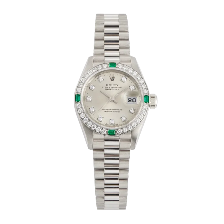 Silver Rolex Datejust 69079 watch with diamond and emerald accents, a date display, and a metallic link bracelet.