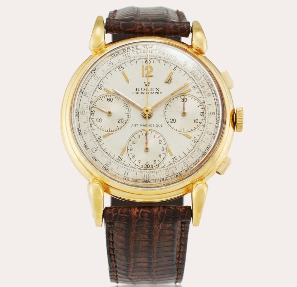 Vintage gold Rolex 4313 chronograph watch with a brown leather strap and three subdials on a white face.