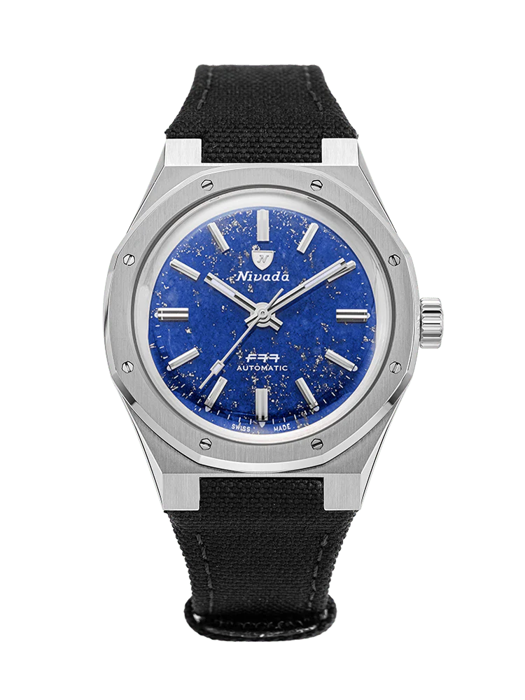 A silver F77 wristwatch with a blue speckled dial, silver markers, and a black fabric strap.