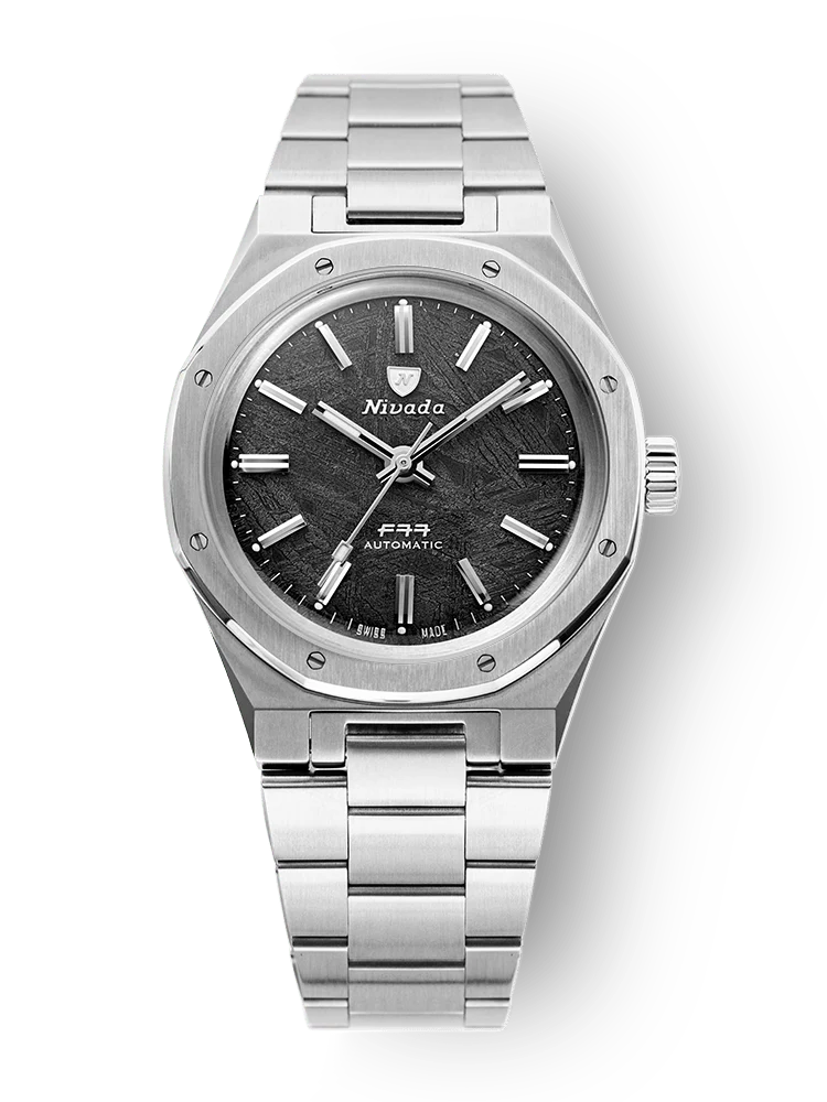 A silver Nivada Grenchen F77 Mirada wristwatch with a black textured dial and metal link band, displayed on a white background.