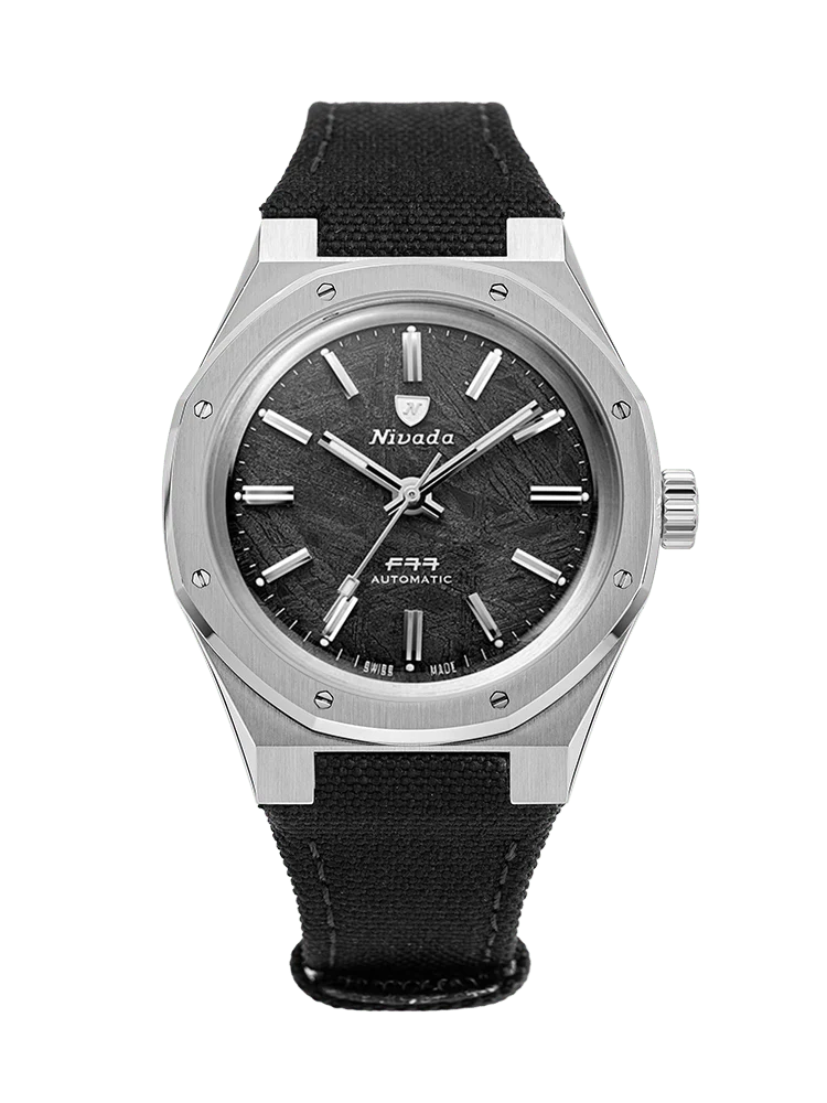 A stainless steel Nivada Grenchen 68016A77-BC wristwatch with a black textured dial and a black fabric strap.