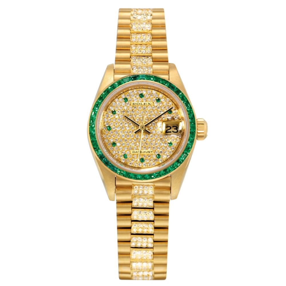 Gold Rolex Datejust 69108 watch featuring a diamond-encrusted face and band, striking green accents, and a date window displaying 23.