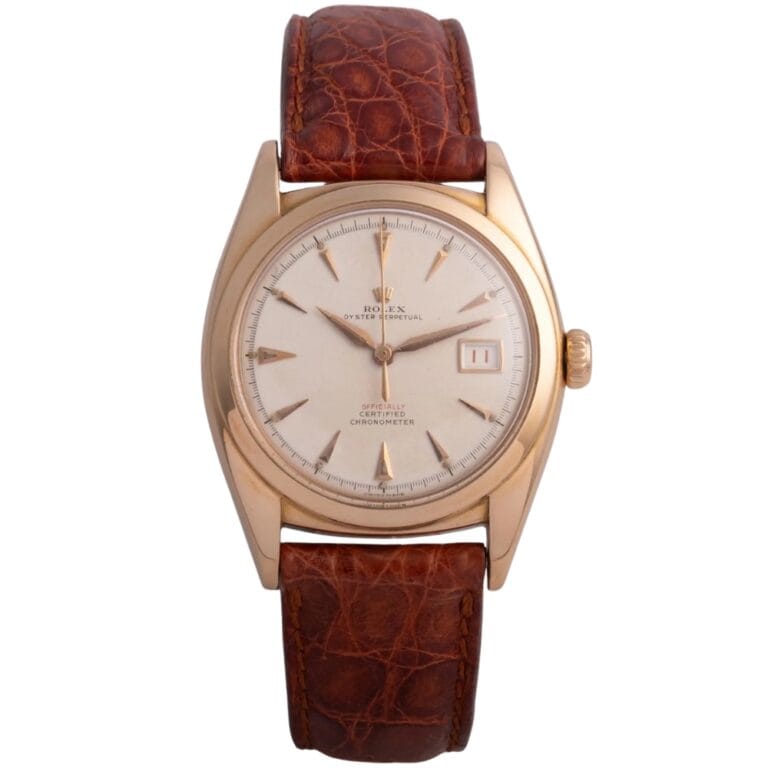Gold Rolex Datejust wristwatch, model 6104, with a brown leather strap and a white dial displaying the date.