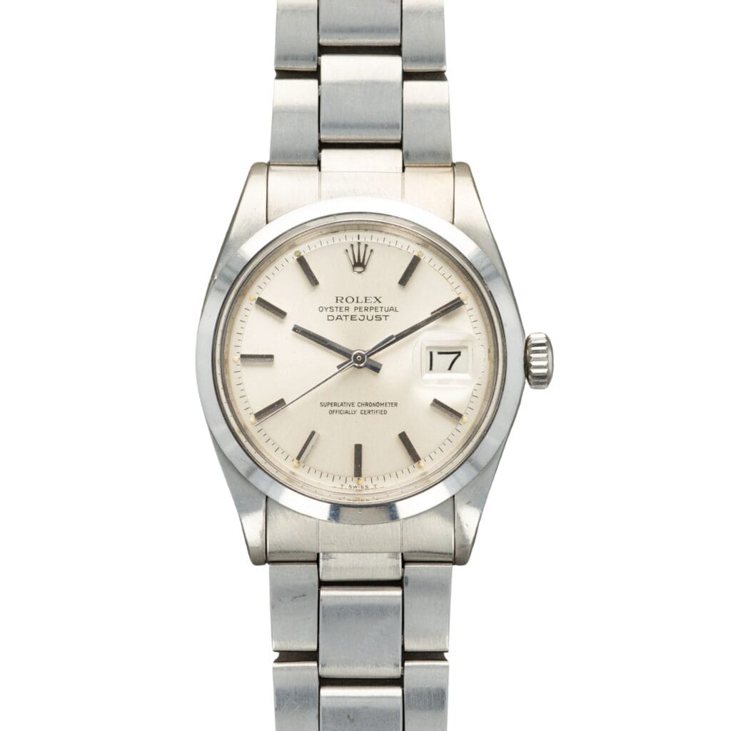 Silver Rolex Datejust 1600 watch with a white dial, metal bracelet, and date window at the 3 o’clock position.