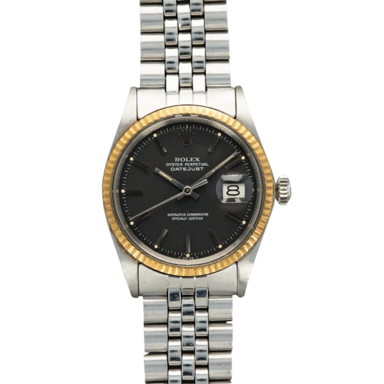A Rolex Datejust 1601 watch with a black dial, gold fluted bezel, and silver jubilee bracelet, displaying the date.