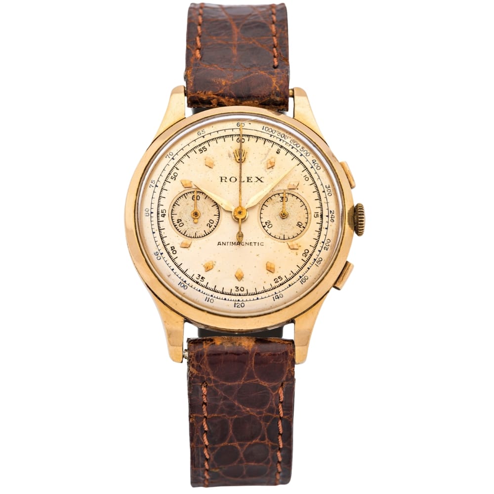 A vintage gold Rolex 3834 chronograph watch featuring a brown leather strap and three elegant subdials.