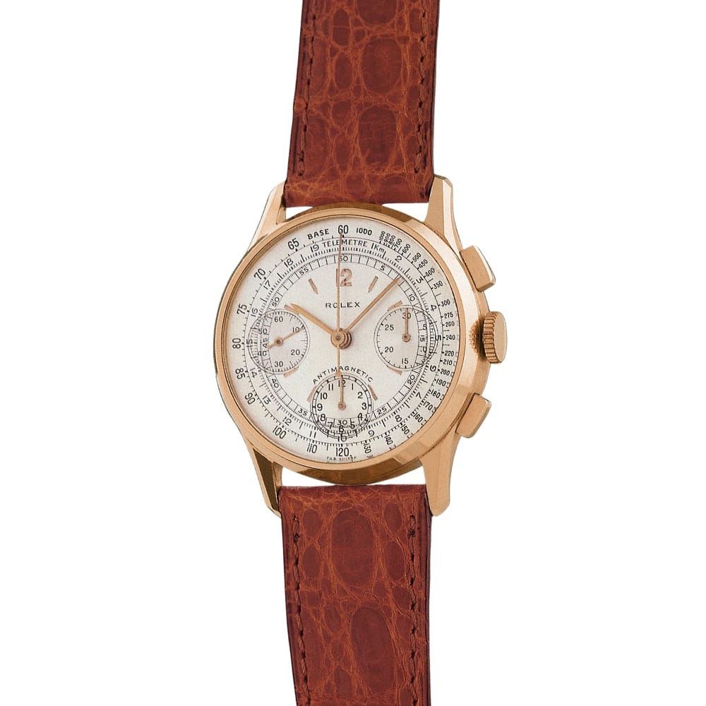 A vintage Rolex Chronograph with a brown leather strap and a detailed dial featuring three subdials and a gold casing.