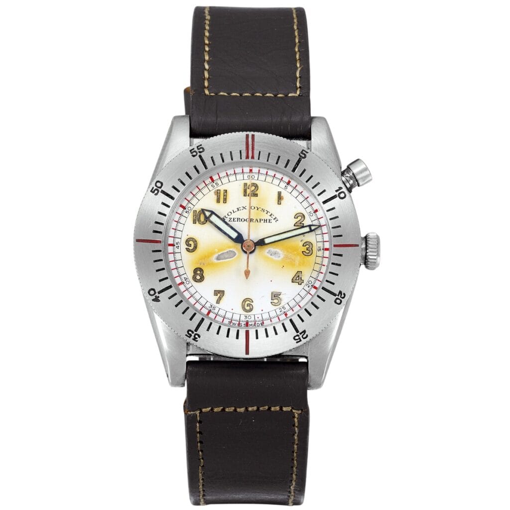 A vintage Rolex Chronograph with a dark leather strap, yellowed dial, and silver bezel with numeric markers.