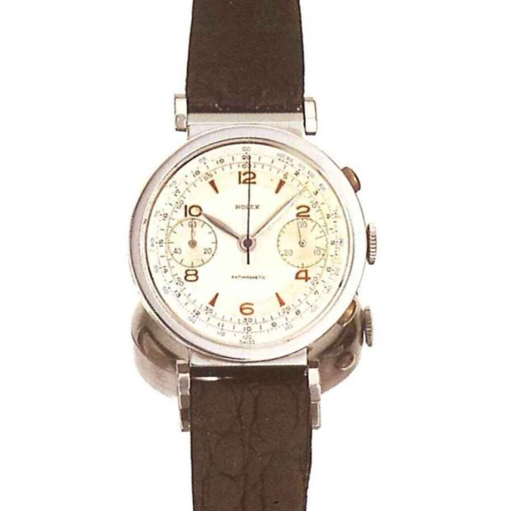 A vintage Rolex Chronograph 2705 wristwatch with a white dial, brown leather strap, and two subdials.