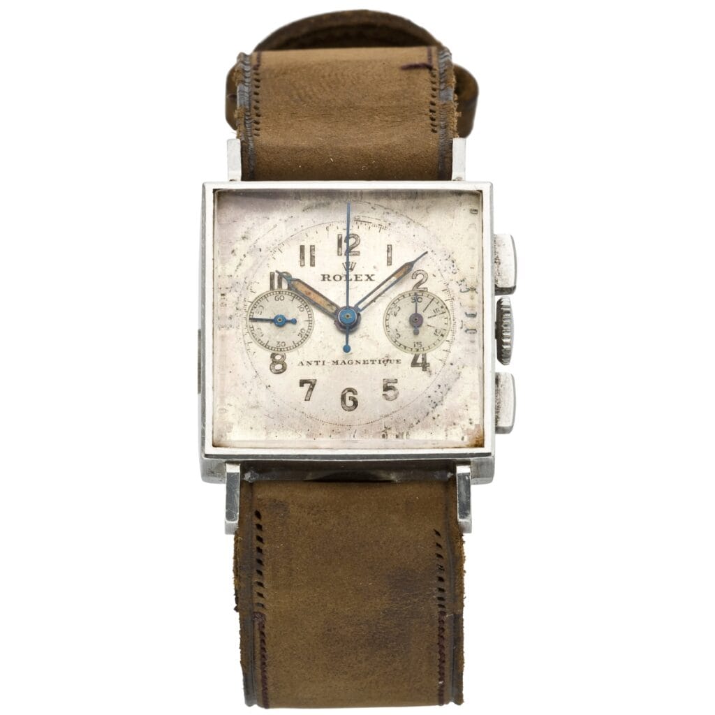 Vintage square Rolex watch with a worn brown leather band, two small subdials on the face, and classic chronograph detailing.