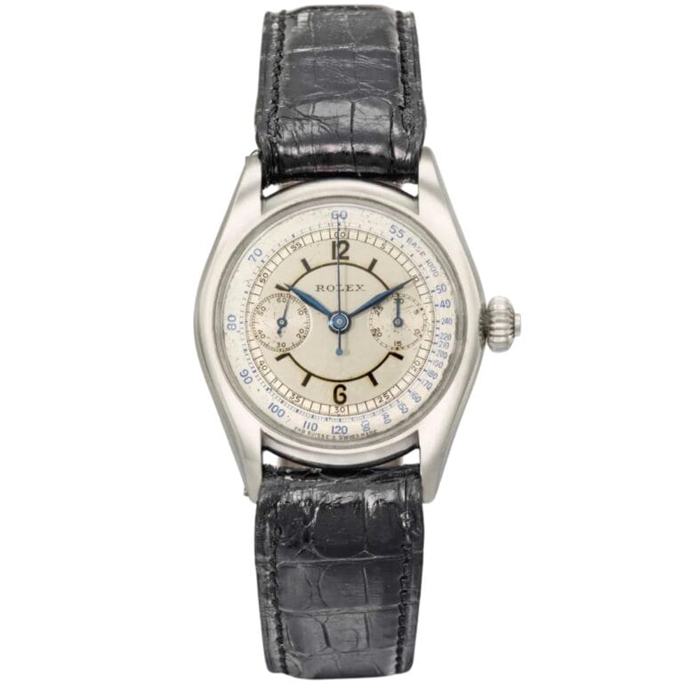 A vintage Rolex chronograph wristwatch with a black leather strap and a silver dial featuring blue and gold accents.