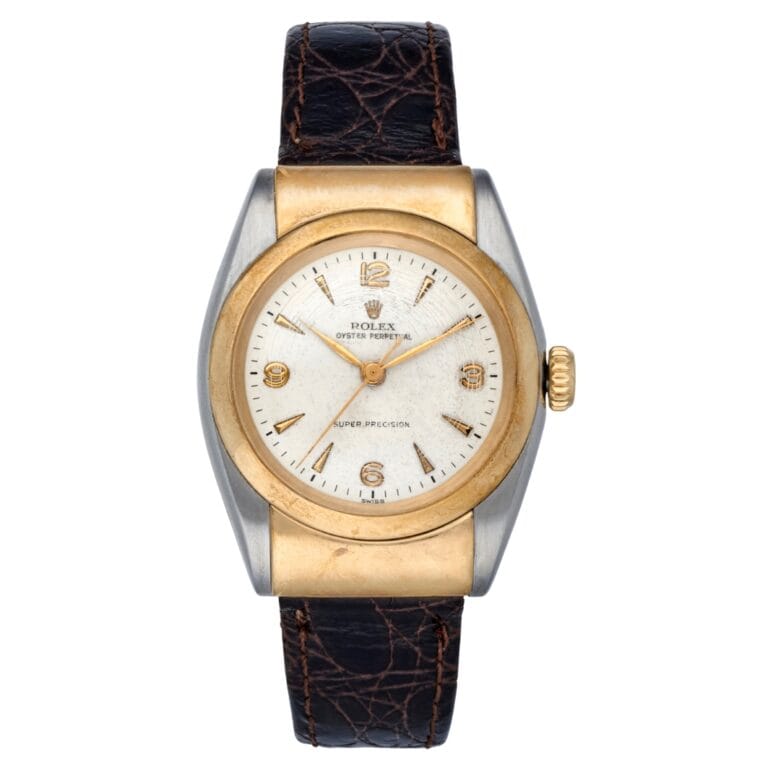 Vintage Rolex Oyster Perpetual 6064 watch featuring a gold bezel, white dial, and black textured leather strap.