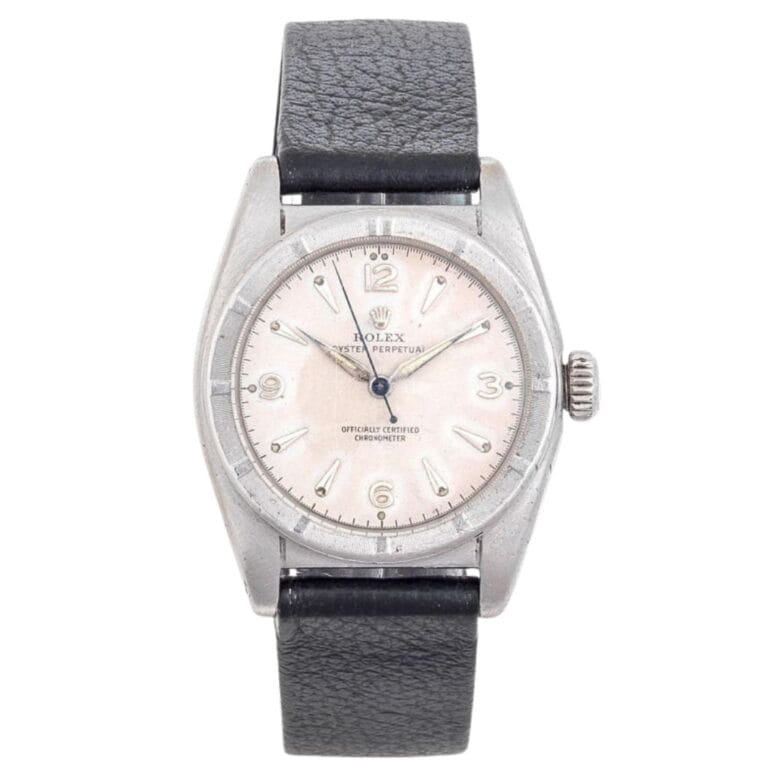 Vintage silver Rolex Oyster Perpetual wristwatch, reference 6015, featuring a black leather strap and a light-colored dial.