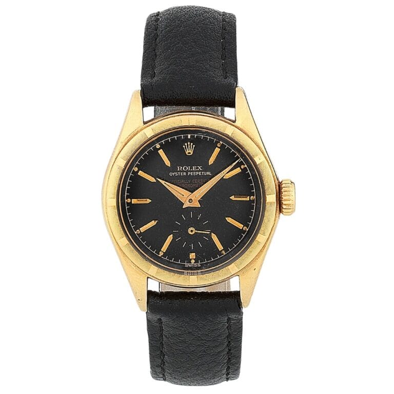 Gold Rolex Oyster Perpetual wristwatch, model 6007, with a black dial and black leather strap, displaying the time as 9:10.