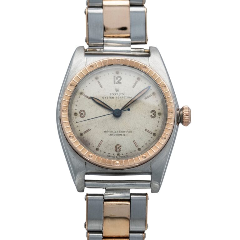 A vintage Rolex Oyster Perpetual 5045 watch featuring a silver and gold two-tone band and a round, worn dial.