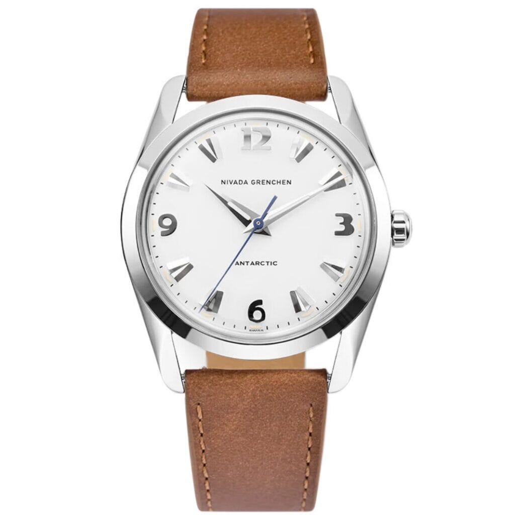 The Nivada Grenchen Antarctic 35005M16 is a luxury watch featuring a silver case, white dial, brown leather strap, and bold black numerals at 3, 6, 9, and 12.