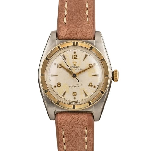 Vintage Rolex Oyster Perpetual wristwatch featuring a brown leather strap and gold-accented bezel on a classic white dial, model 5015.