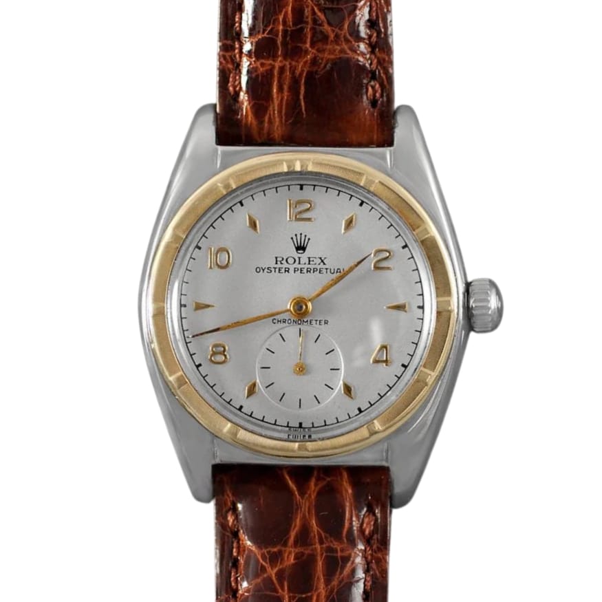 Vintage Rolex Oyster Perpetual 5013 watch with a brown leather strap and a silver dial featuring elegant gold accents.