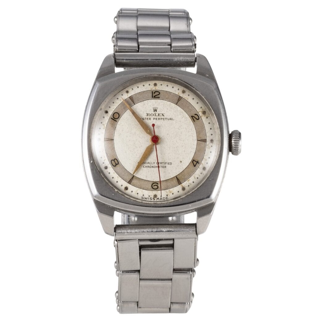 A vintage Rolex Oyster Perpetual wristwatch with a round white dial, silver case, and metal link bracelet. Model 4961.