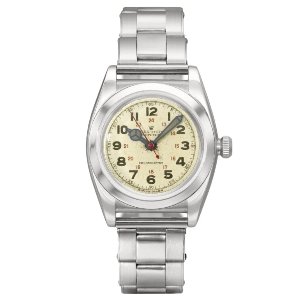 A vintage Rolex Oyster Perpetual stainless steel wristwatch featuring a cream dial, Arabic numerals, and a classic metal link bracelet.