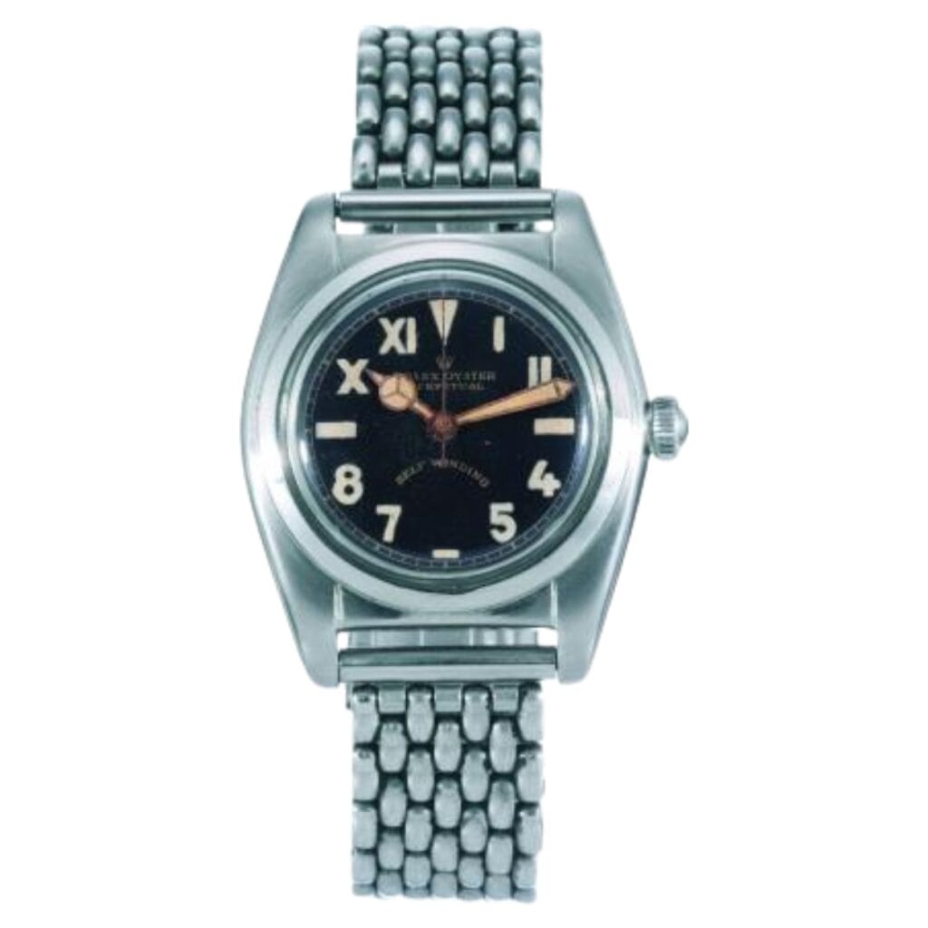 A vintage Rolex Oyster Perpetual stainless steel wristwatch, model 2490, with a black dial and metal link bracelet, displaying Roman and Arabic numerals.
