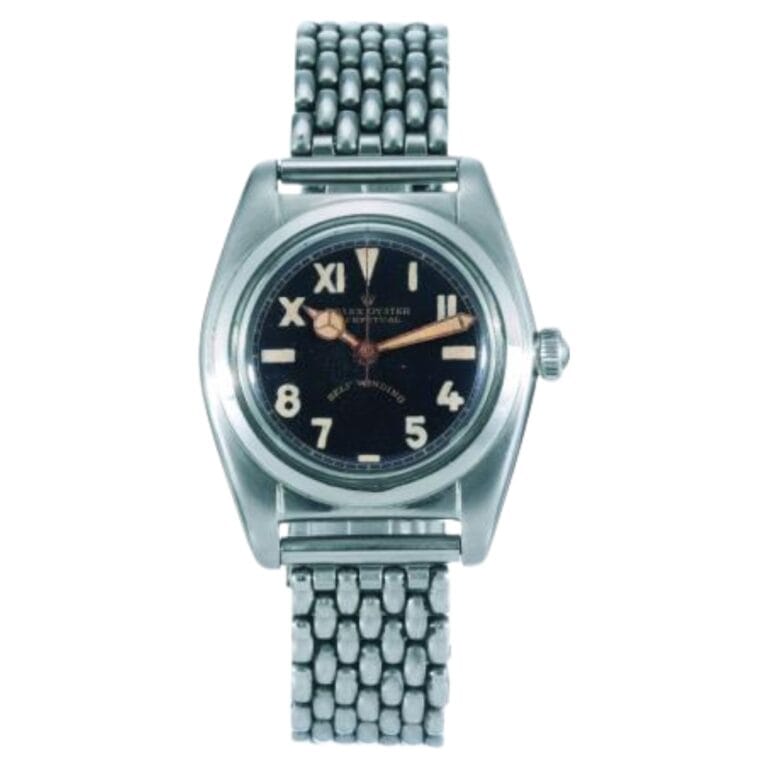 A vintage Rolex Oyster Perpetual stainless steel wristwatch, model 2490, with a black dial and metal link bracelet, displaying Roman and Arabic numerals.