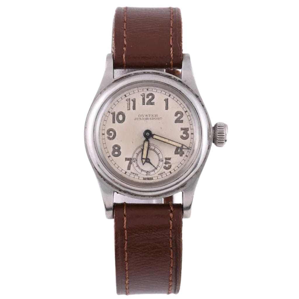 Vintage Rolex Oyster wristwatch with a brown leather strap and a silver case, displaying Arabic numerals.