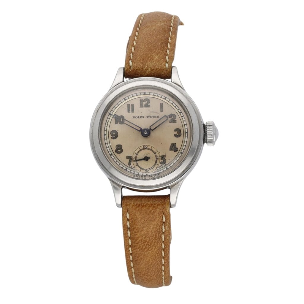 A vintage Rolex Oyster wristwatch with a tan leather strap and beige dial displaying Arabic numerals.