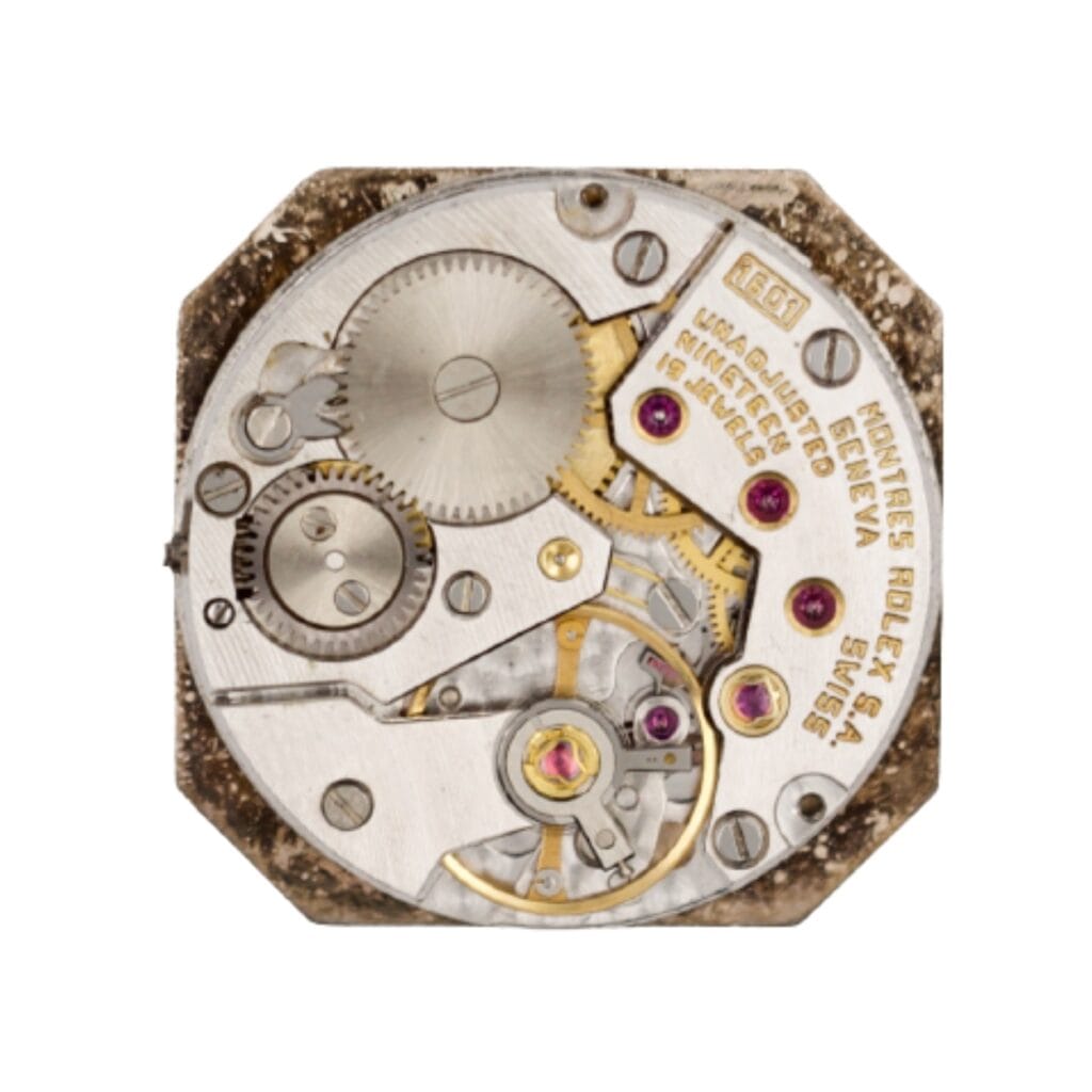 Close-up of a vintage mechanical watch movement with gears, jewels, and engraved text on a metal plate.